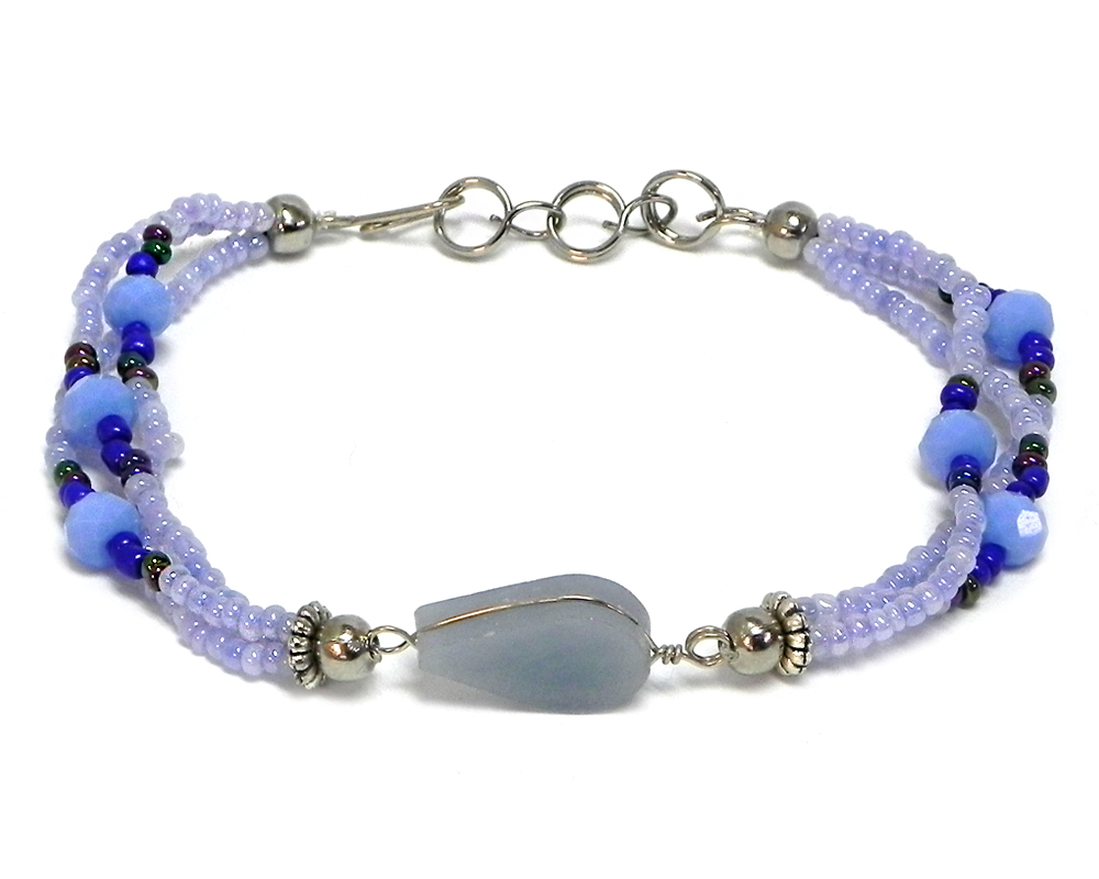 BR-020901150599 Handmade seed bead and crystal bead multi strand bracelet with teardrop-cut angelite gemstone crystal cabochon centerpiece in light blue periwinkle, blue, and iridescent black color combination.