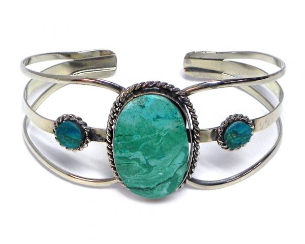 Handmade silver metal cuff bracelet with large oval-cut gemstone crystal cabochon centerpiece in teal green chrysocolla.