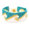 Handmade Czech glass seed bead wide strap bracelet with wave pattern design in turquoise blue, white, and gold color combination.