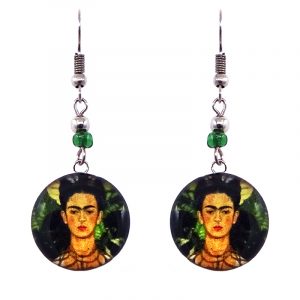 Handmade round silver Frida inspired painting earrings with acrylic, seed beads, and metal hooks in dark green, green, orange, and black color combination.