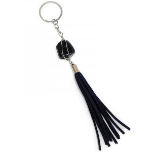 Handmade wire wrapped tumbled gemstone crystal with suede tassel dangle on silver metal key ring in dark blue goldstone.