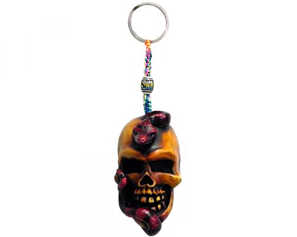 Handmade durepox resin figurine keychain of a beige skull with a slithering red snake.