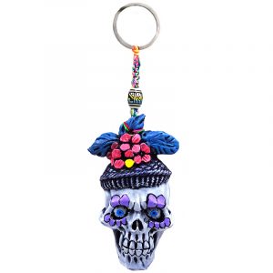 Handmade durepox resin figurine keychain of a New Orleans themed Mardi Gras sugar skull with a purple and multicolored floral designs.
