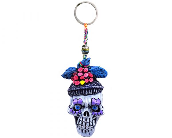 Handmade durepox resin figurine keychain of a New Orleans themed Mardi Gras sugar skull with a purple and multicolored floral designs.