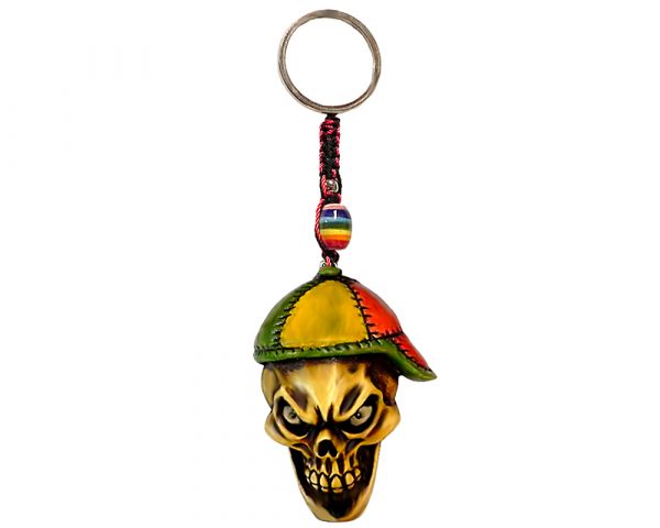 Handmade durepox resin figurine keychain of an evil beige skull wearing a hat in Rasta colors.