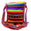 Handmade medium-sized slim square-shaped purse bag with multicolored tribal print striped pattern material (or manta Inca) and fringe in rainbow colors.