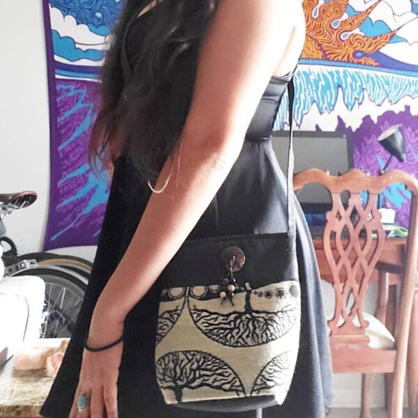 Medium-sized cushioned square-shaped purse bag with tree of life print pattern and coconut button and beads in beige and black color combination.