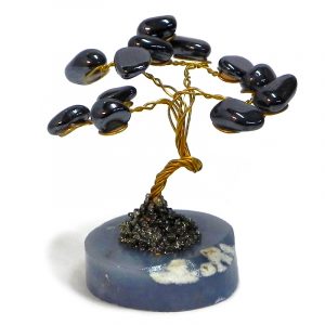 Handmade golden-colored metal wire and tumbled dark gray hematite gemstone crystal tree of life table ornament with crushed pyrite and a round stone base.