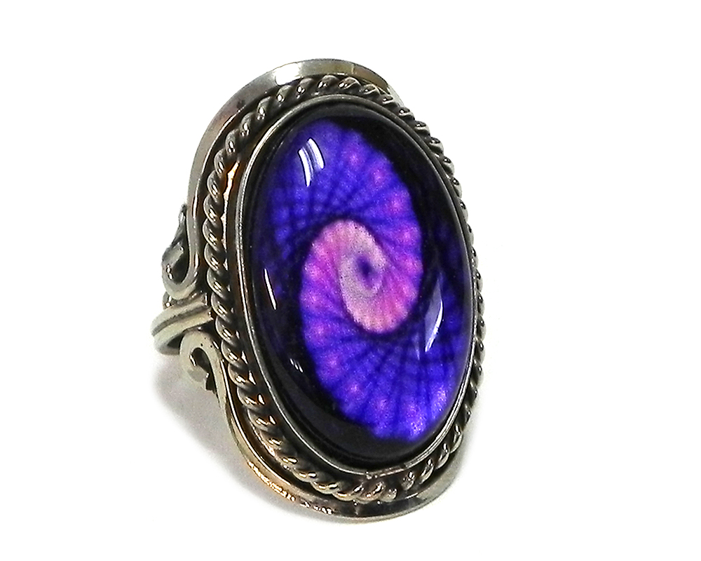 Handmade oval-shaped acrylic New Age themed psychedelic spiral graphic design on alpaca silver metal ring with rope edge border in purple, lilac, indigo, and black color combination.