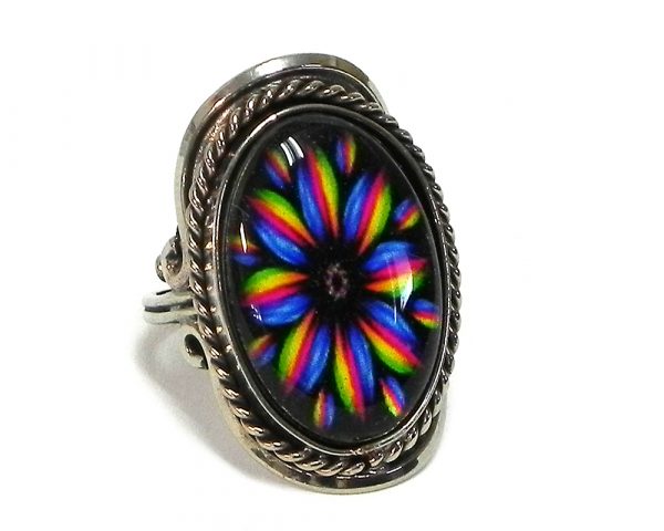 Handmade oval-shaped acrylic New Age themed floral mandala graphic design on alpaca silver metal ring with rope edge border in rainbow color combination.