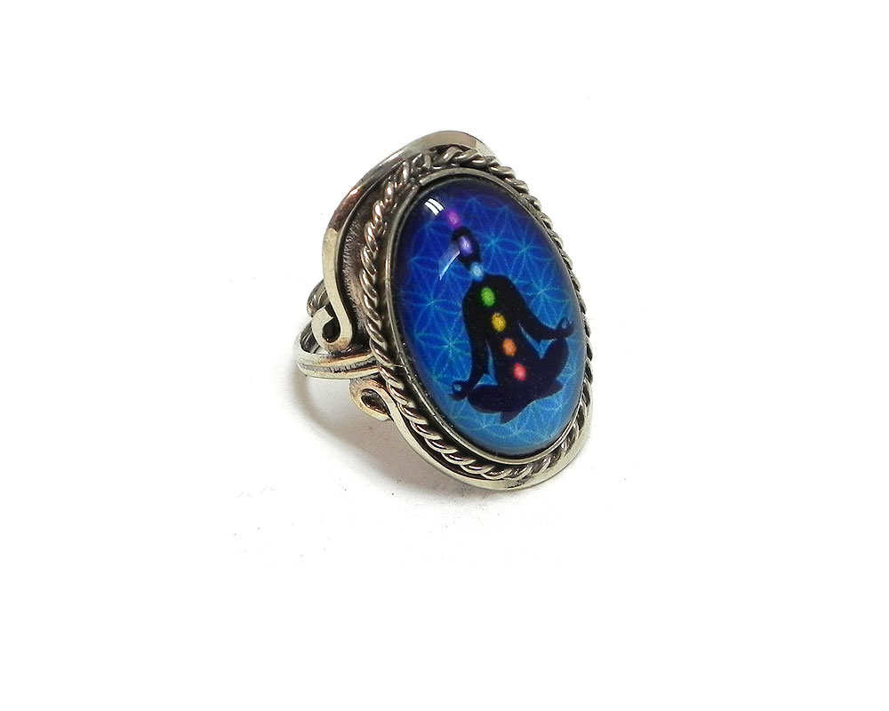 Handmade oval-shaped acrylic New Age themed flower of life chakra graphic design on alpaca silver metal ring with rope edge border in turquoise blue and rainbow multicolored color combination.
