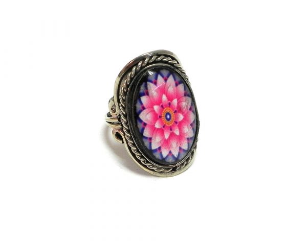 Handmade oval-shaped acrylic New Age themed floral mandala graphic design on alpaca silver metal ring with rope edge border in light pink, hot pink, blue, and golden yellow color combination.