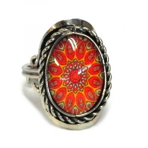 Handmade small oval-shaped acrylic New Age themed psychedelic floral mandala graphic design on alpaca silver metal ring with rope edge border in orange, red, and golden yellow color com