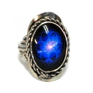 Handmade small oval-shaped acrylic New Age themed mystical floral mandala graphic design on alpaca silver metal ring with rope edge border in blue, black, and pink color combination.