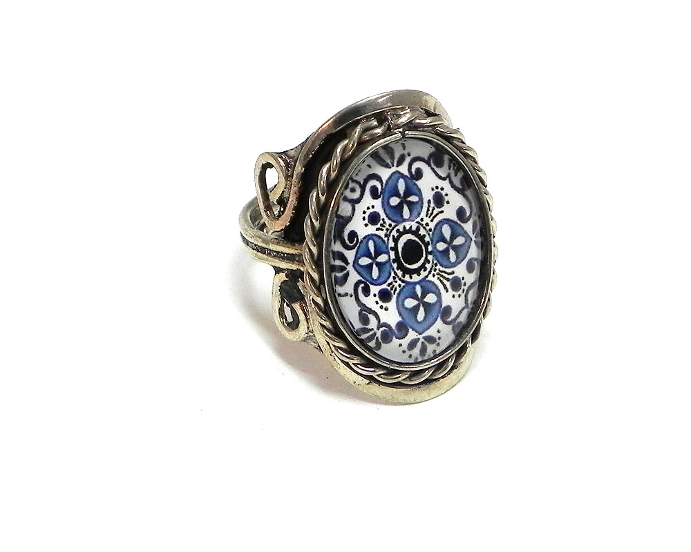 Handmade oval-shaped acrylic vintage themed floral mandala graphic design on alpaca silver metal ring with rope edge border in white, blue, and dark blue color combination.