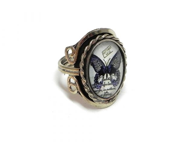 Handmade oval-shaped acrylic vintage themed butterfly graphic design on alpaca silver metal ring with rope edge border in black and white color combination.