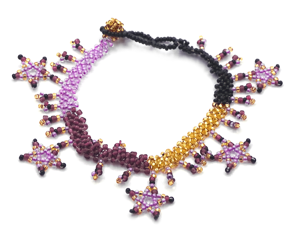 Handmade Czech glass seed bead anklet with beaded stars and fringe dangles in purple, lavender, gold, and black color combination.