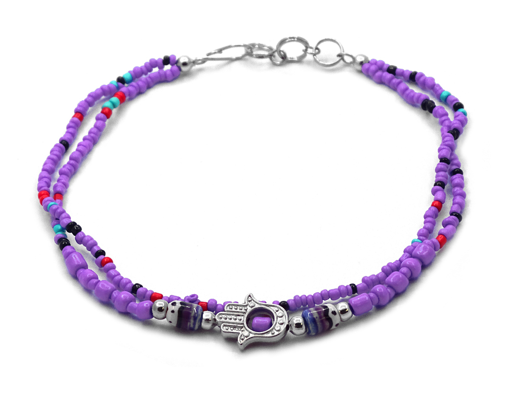 Handmade seed bead multi strand anklet with silver metal hamsa hand charm and tribal pattern bead centerpiece in purple, red, and mint turquoise color combination.