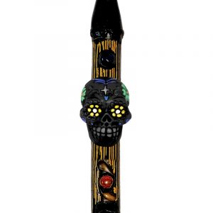 Handcrafted tobacco smoking natural bamboo wooden peace pipe of a black Day of the Dead sugar skull with multicolored floral designs.