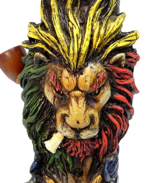 Handcrafted tobacco smoking water pipe of a smoking lion head with a scar on one eye, Rasta-colored mane, and green and gold peace sign necklace.