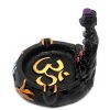Handcrafted round incense holder ash tray with a gold om sign, lotus design, and a black 3D figurine of a meditating body with 7 chakra rainbow-colored tumbled gemstone crystals.