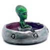 Handcrafted round incense holder ash tray in a flying saucer shape with a galaxy design and a 3D figurine of an alien in green, silver, dark purple, red, white, and black color combination.