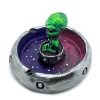 Handcrafted round incense holder ash tray in a flying saucer shape with a galaxy design and a 3D figurine of an alien in green, silver, dark purple, red, white, and black color combination.