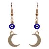 Handmade metal crescent moon charm dangle earrings with evil eye bead in blue, white, black, and gold color combination.