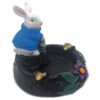 Handcrafted round incense holder ash tray with a flower and leaf design and 3D figurine of a rabbit holding money in turquoise, green, black, and gold color combination.