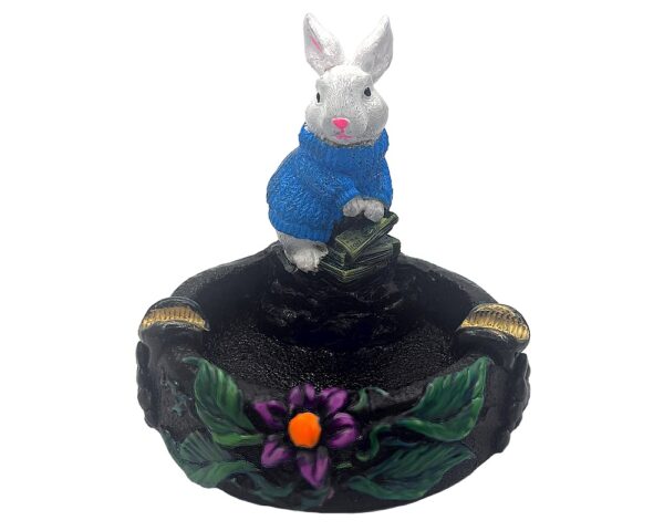 Handcrafted round incense holder ash tray with a flower and leaf design and 3D figurine of a rabbit holding money in turquoise, green, black, and gold color combination.